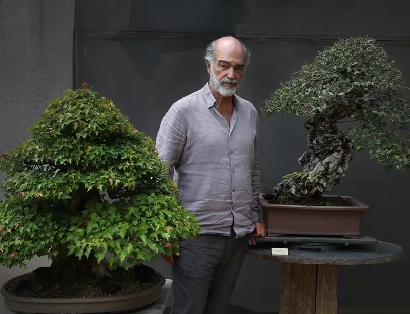 Luis Vallejo between two bonsai